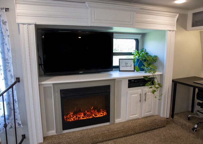 Fireplace and entertainment center with white trim and light gray walls.