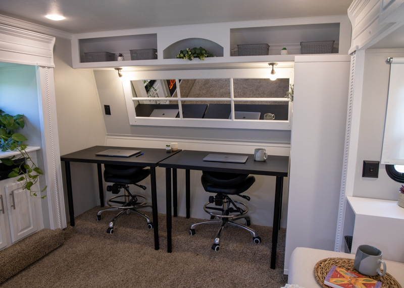 Two desks in a room with white trim and light gray walls.